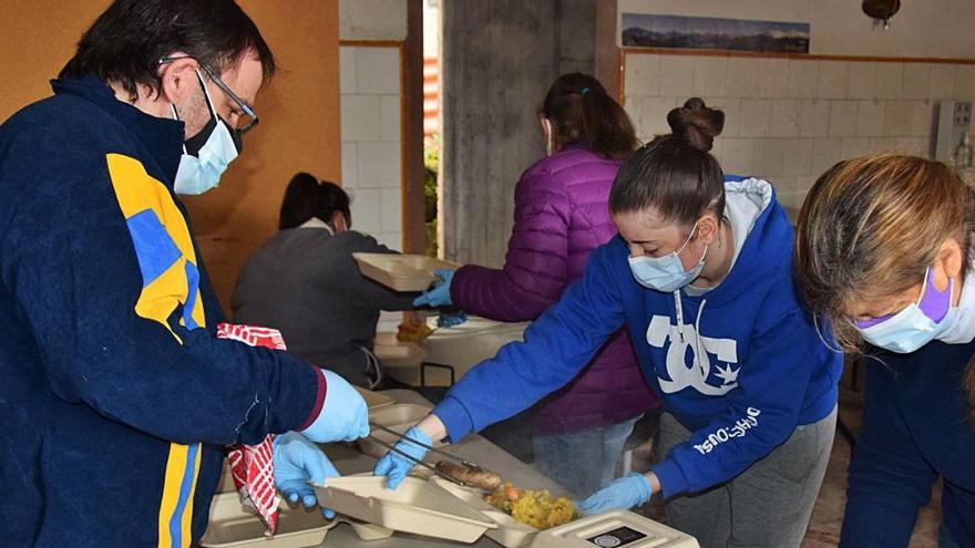 Els col·laboradors omplen els tàpers d&#039;arròs, botifarra i mandarines