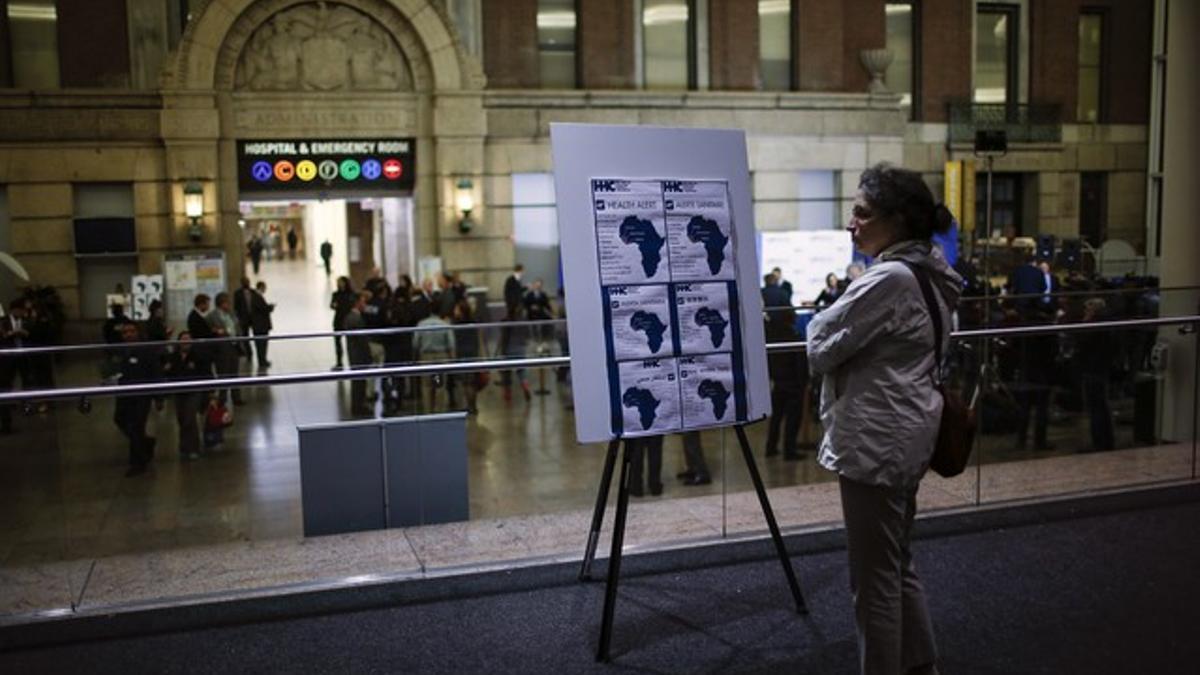 Una mujer ante un cartel con información sobre el ébola en el Hospital Bellevue de Nueva York donde está incresado el doctor Craig Spencer.