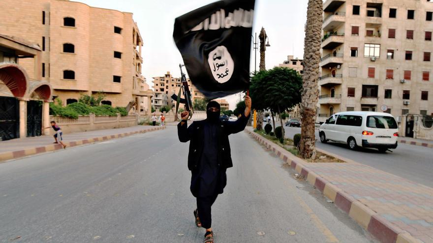 Miembro de Estado Islámico con una bandera durante un desfile militar en la ciudad siria de Raqqa en 2014.