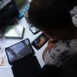 Archivo - Un niño usa el teléfono móvil y una tablet, a 18 de octubre de 2023, en Madrid (España).