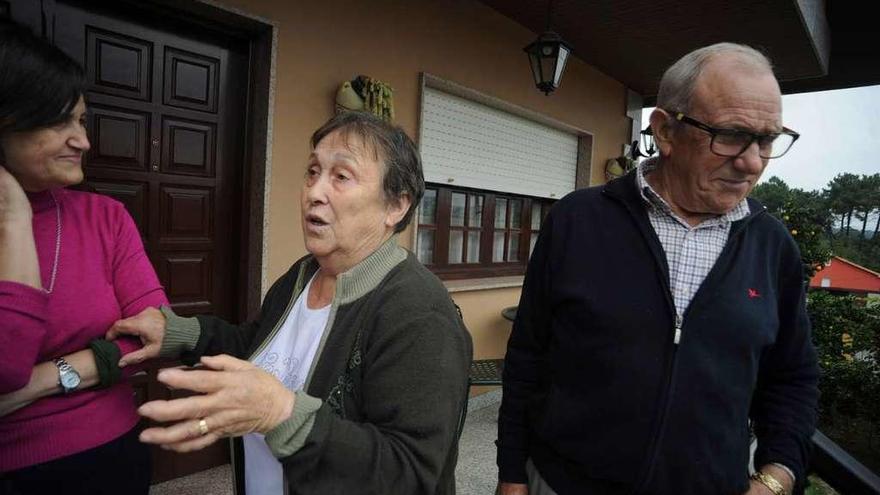 Argentina y su marido Avelino con una de sus hijas en la entrada de la casa explican el susto que se llevaron. // Iñaki Abella