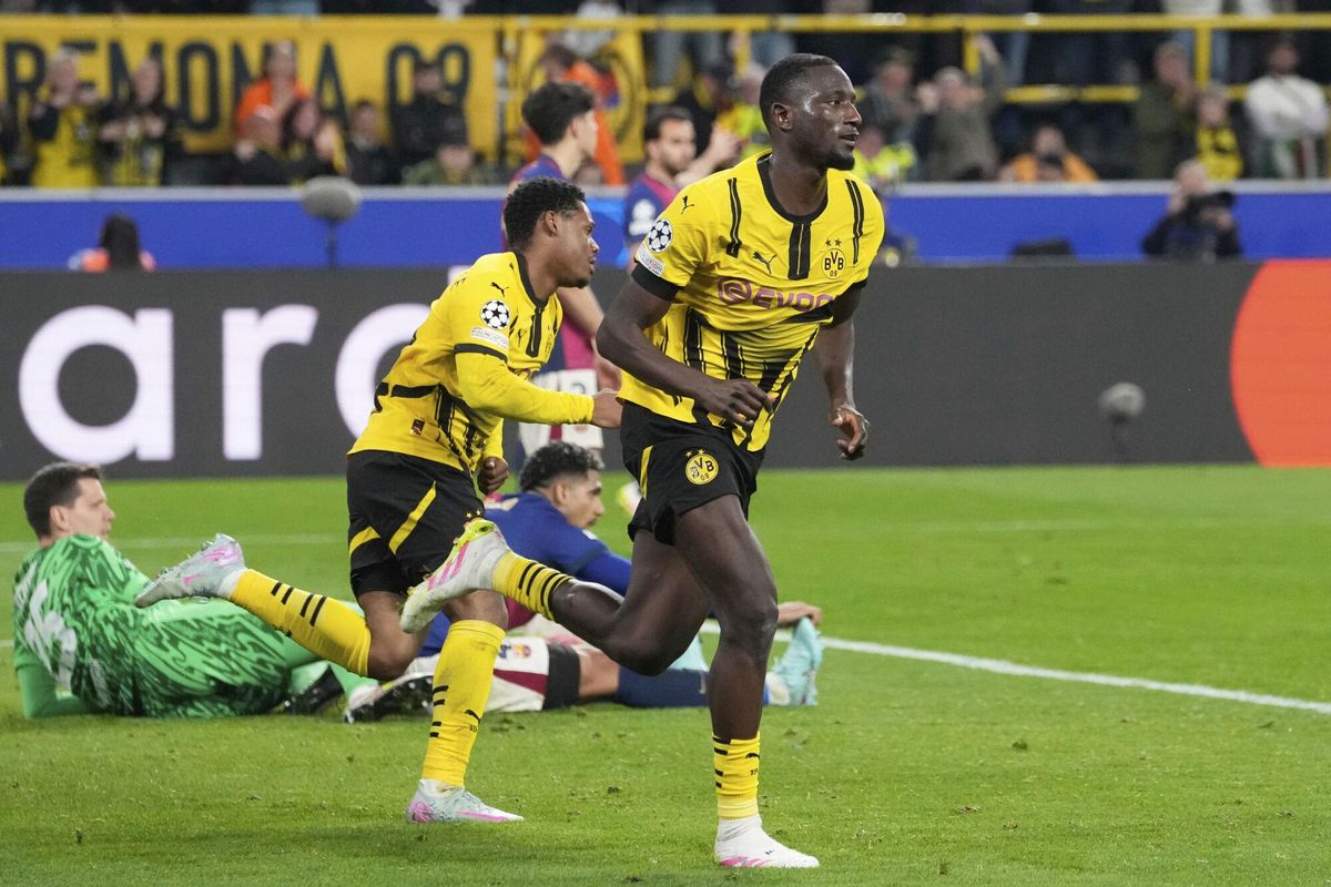 Dortmunds Serhou Guirassy, right, celebrates after scoring his sides third goal during the Champions League quarterfinals second leg soccer match between Borussia Dortmund and Barcelona, at the Signa-Iduna Park in Dortmund, Germany, Tuesday, April 15, 2025. (AP Photo/Martin Meissner)