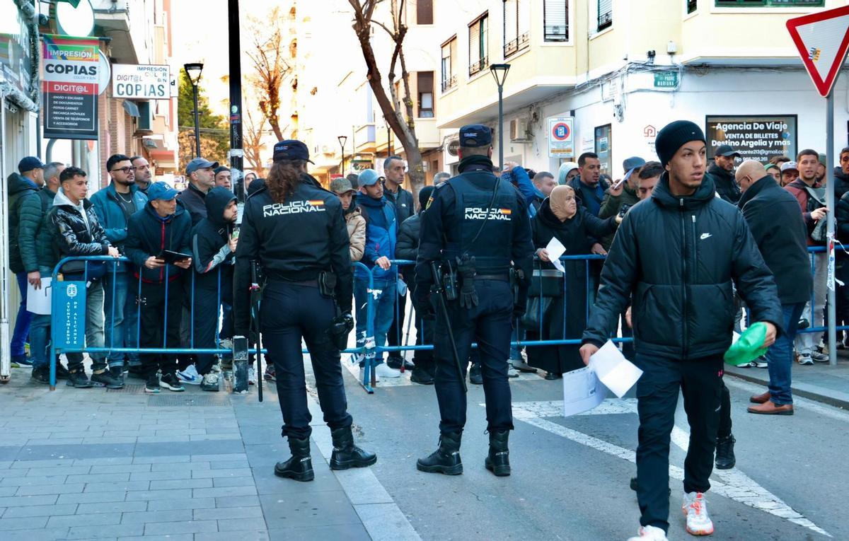 Dos agentes en la mañana de este sábado regulando el paso de personas a las colas del Consulado Argelino en Alicante.