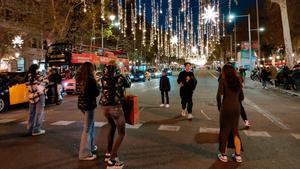 Un grupo de paseantes echan fotos a las luces de Navidad del paseo de Gràcia