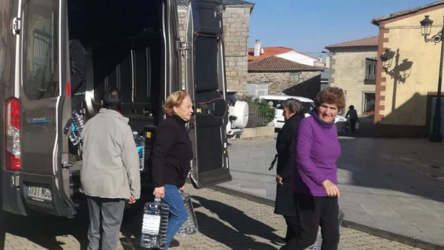 Vecinas de Rabanales recogen las garrafas de agua de la Diputación para suplir la avería. | Ch. S.