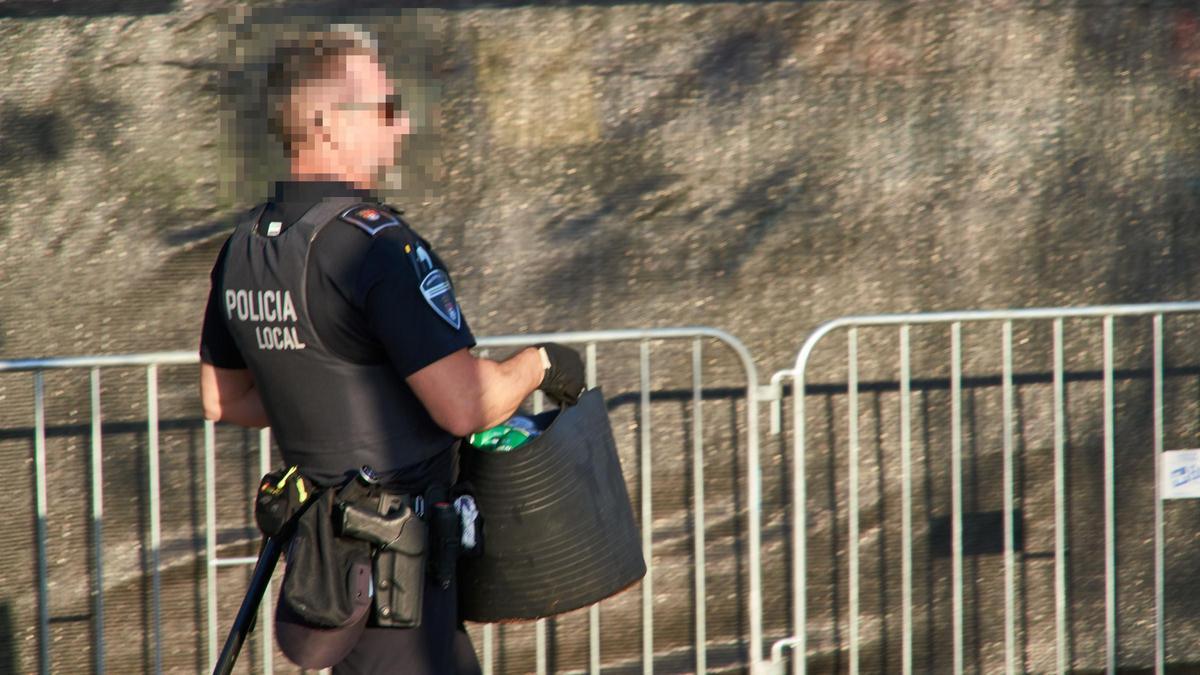 Un agente de Policía Local retira bebidas de la venta ilegal en Extremúsika.