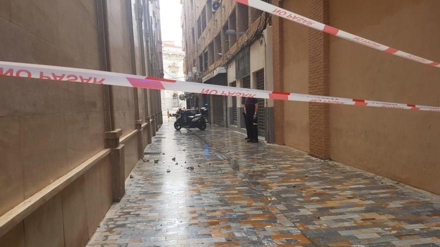 Los agentes cortan la calle donde ha caído la cornisa.