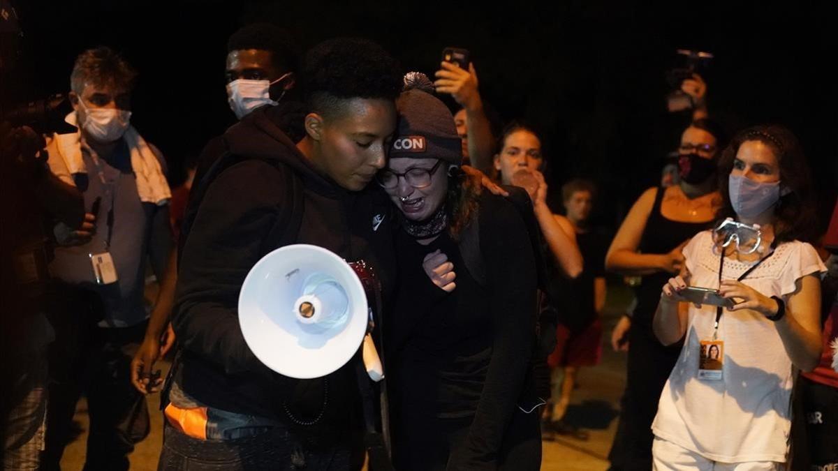 Dos manifestantes lloran en la manifestación de repulsa por los dos hombres muertos por disparos la noche del martes en Kenosha.