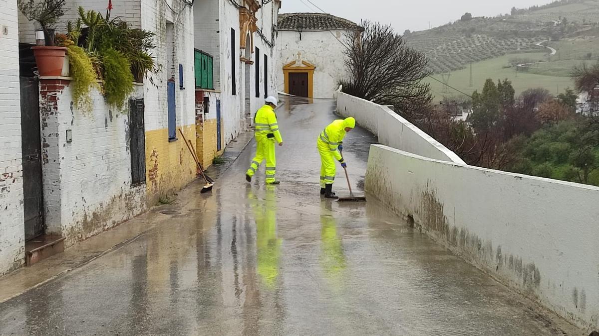 Miembros de la unidad de servicios evacuan agua proveniente de la ladera sur de Baena.
