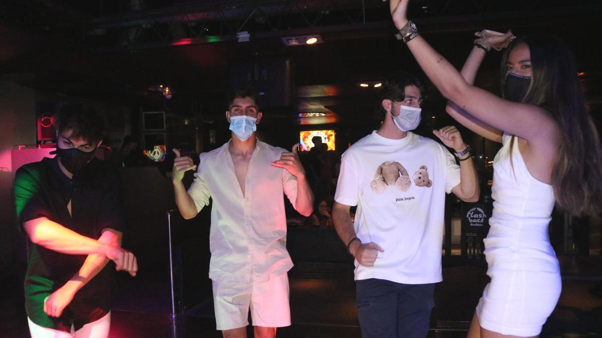 Pla mig d&#039;un grup de joves que balla amb mascareta a la pista de la discoteca Flashback de Salou