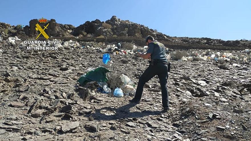 Un agente del Seprona junto a los plásticos en un entorno natural de Juan Grande.