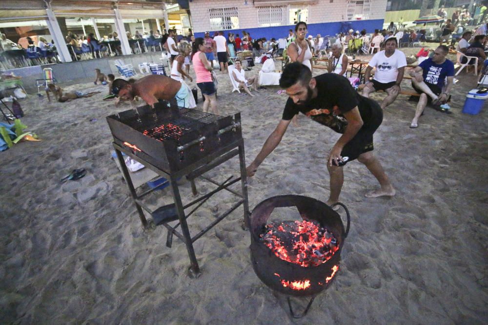 Noche de hogueras, baños, en las playas de la Vega Baja. En las imágenes grupos de amigos y familias en la playa del Cura de Torrevieja