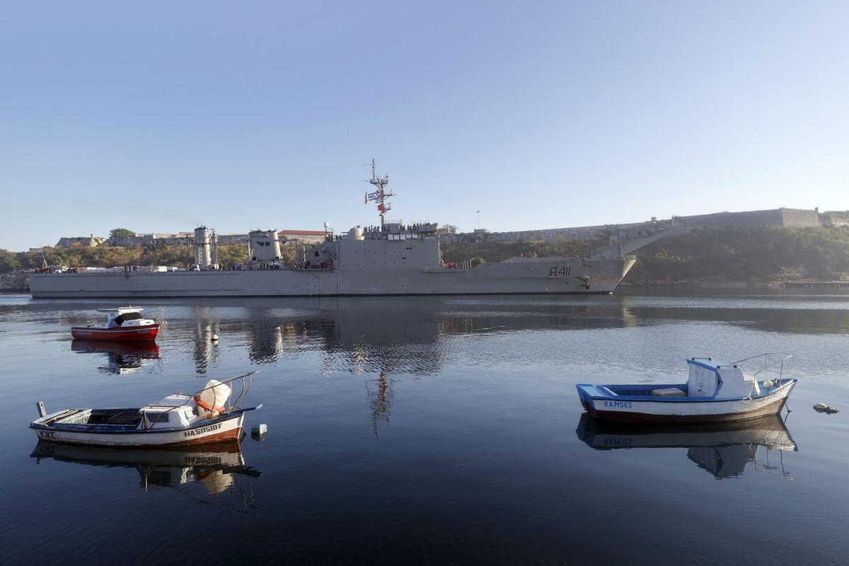 Pequeñas embarcaciones navegan frente a un barco de ayuda humanitaria procedente de México, en el puerto de La Habana (Cuba).