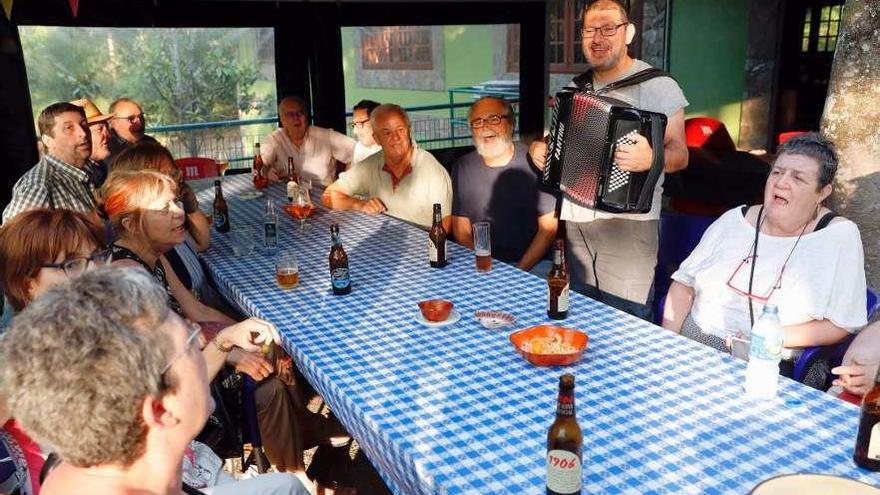 Luis Prego con su acordeón cantando con uno de los grupos a los que instruye. // J.Lores