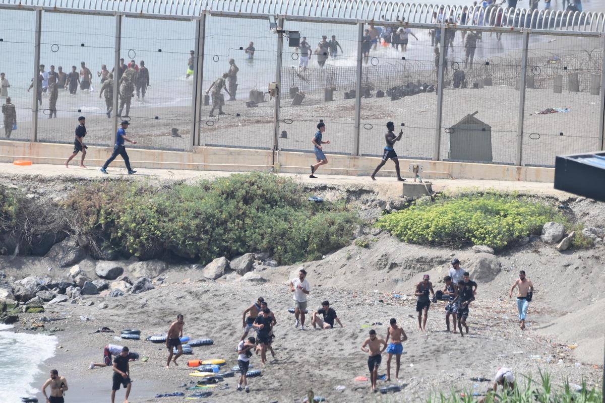 Varios migrantes intentan cruzar la frontera a nado, a 30 de julio de 2026, en Ceuta (España).