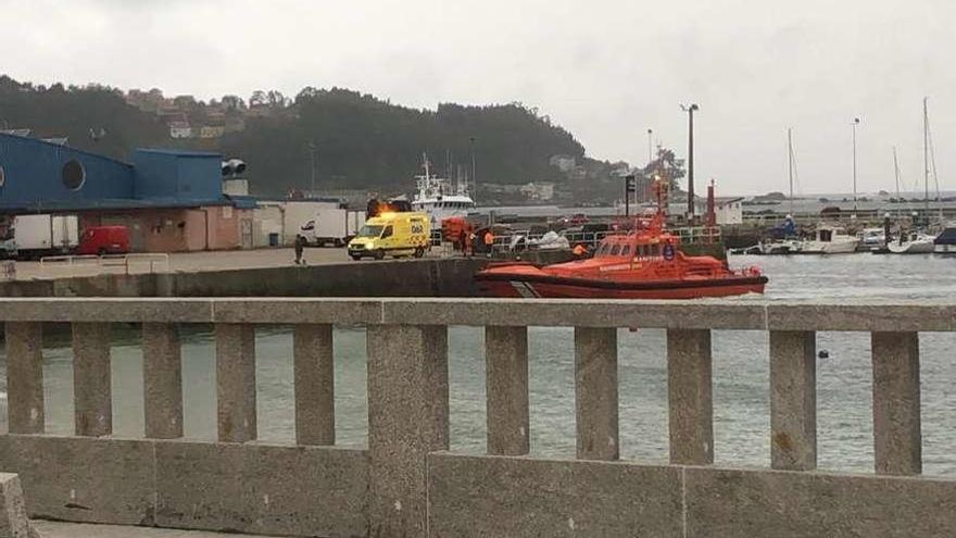 La lancha de salvamento y la ambulancia que trasladaron a la accidentada, en el muelle. // Faro