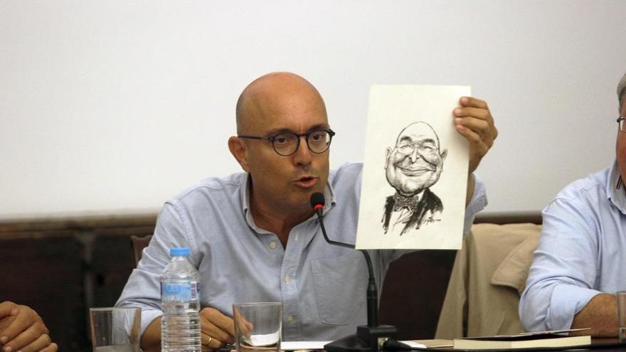 Alfonso Vázquez, mostrando una de las caricaturs de Antonio Garrido.