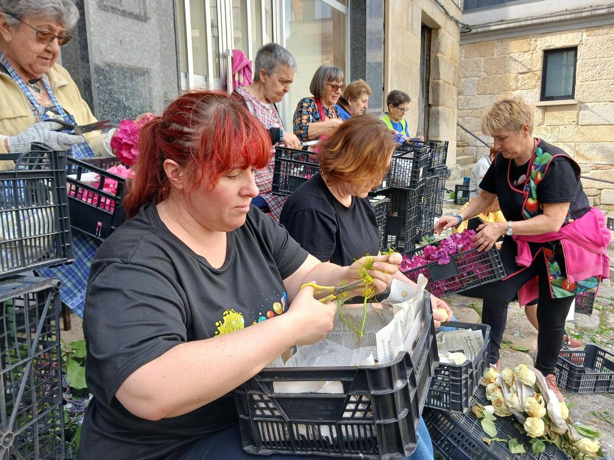 Vecinos de Cangas trabajan en la alfombra de la calle Cervantes, en la muralla de San Leonardo