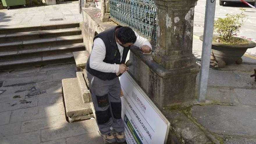 Un operario trabaja en la restauración de la fuente. // FdV