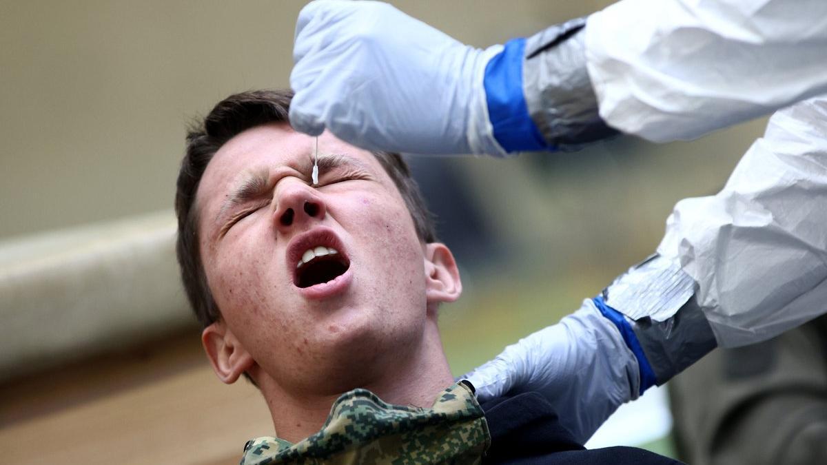 Un joven reacciona mientras le practican un test de antígenos en Austria.