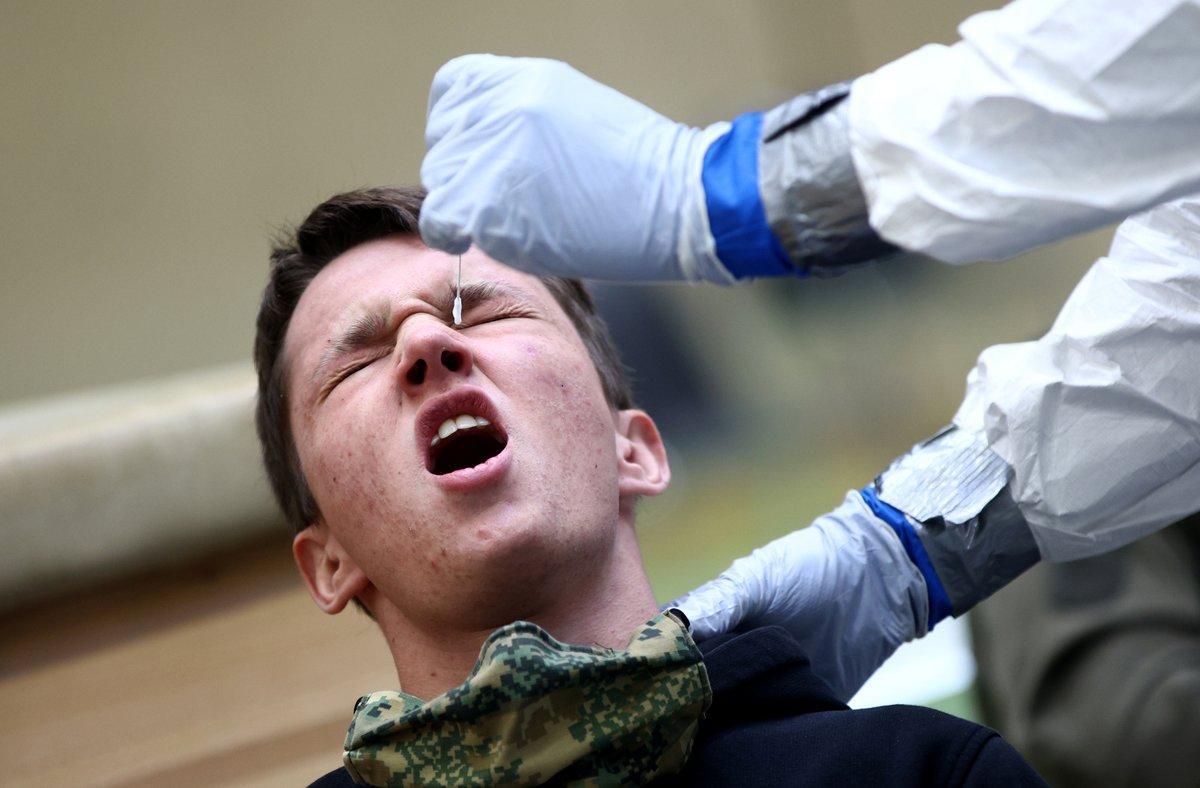 A person reacts as a doctor takes a swab from his nose for an antigen rapid test at a mass testing station operated by the Austrian armed forces during the coronavirus disease (COVID-19) outbreak in Korneuburg, Austria, November 27, 2020. REUTERS/Lisi Niesner