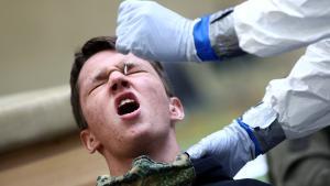 A person reacts as a doctor takes a swab from his nose for an antigen rapid test at a mass testing station operated by the Austrian armed forces during the coronavirus disease (COVID-19) outbreak in Korneuburg, Austria, November 27, 2020. REUTERS/Lisi Niesner