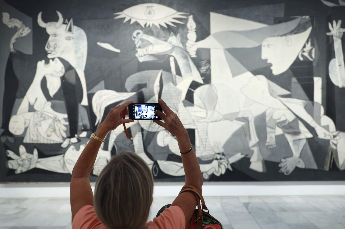Una visitante realiza una foto al Guernica.