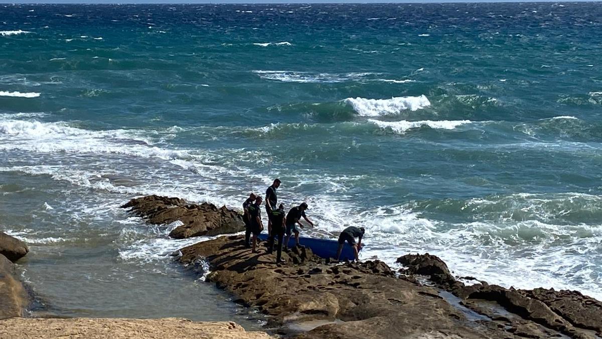 Agentes junto a la patera que ha llegado este domingo a Alicante.