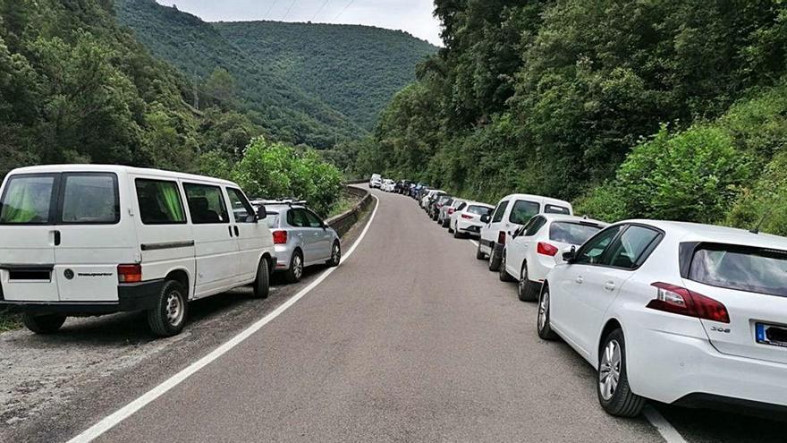 Vehicles aparcats a banda i banda de la carretera d&#039;accés a Sadernes