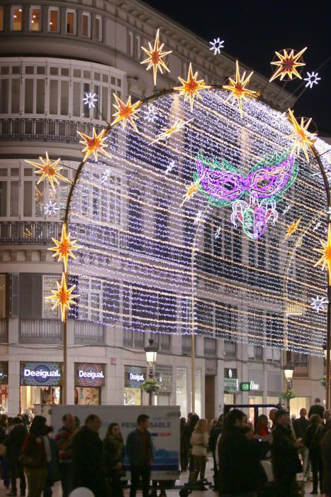 La principal calle del centro de Málaga ya luce los motivos carnavalescos, máscaras y antifaces, con motivo de la Fiesta del Invierno Cálido de la ciudad