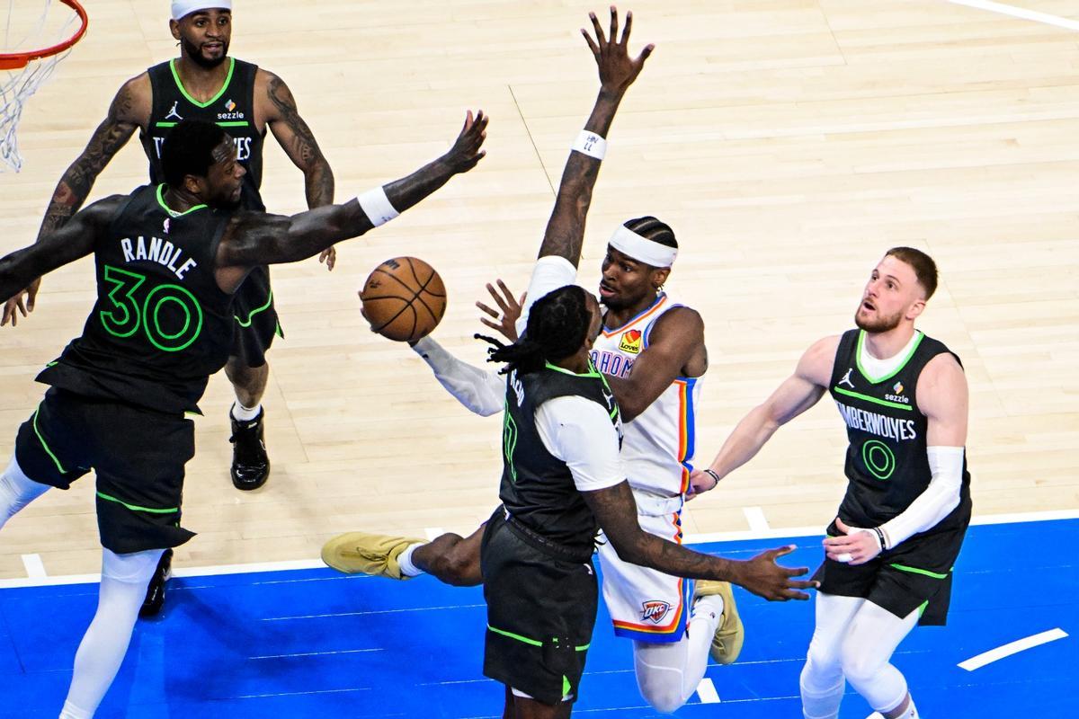 Gilgeous-Alexander lanza a canasta entre cuatro jugadores de los Timberwolves.