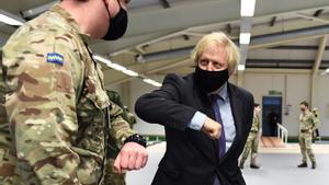El primer ministro británico, Boris Johnson, saluda a un militar en un centro de vacunación abierto en la ciudad escocesa de Glasgow.