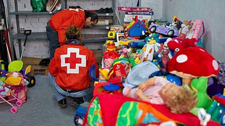 Dos voluntarios de Cruz Roja organizan los juguetes donados en una campaña anterior.