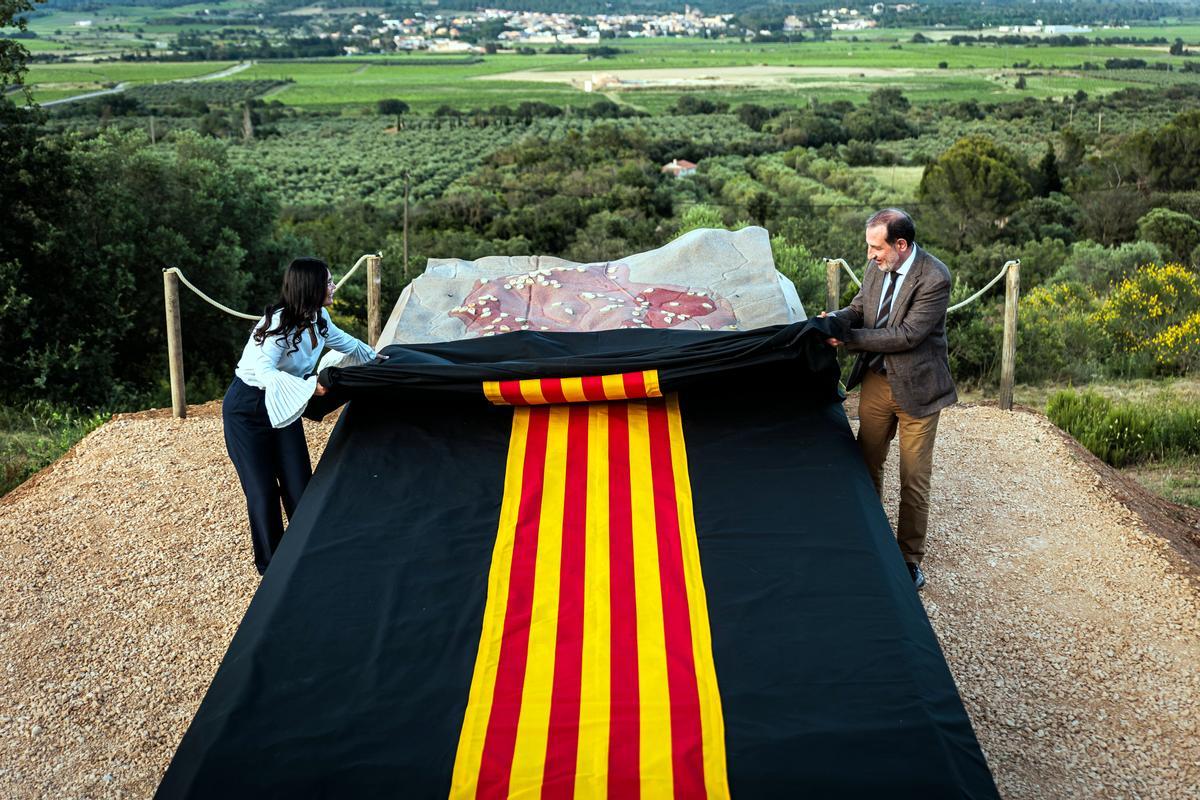 El conseller Espadaler i l'alcaldessa de Garriguella, Raquel Salas, descobreixen l'obra Pedra dels búnquers.