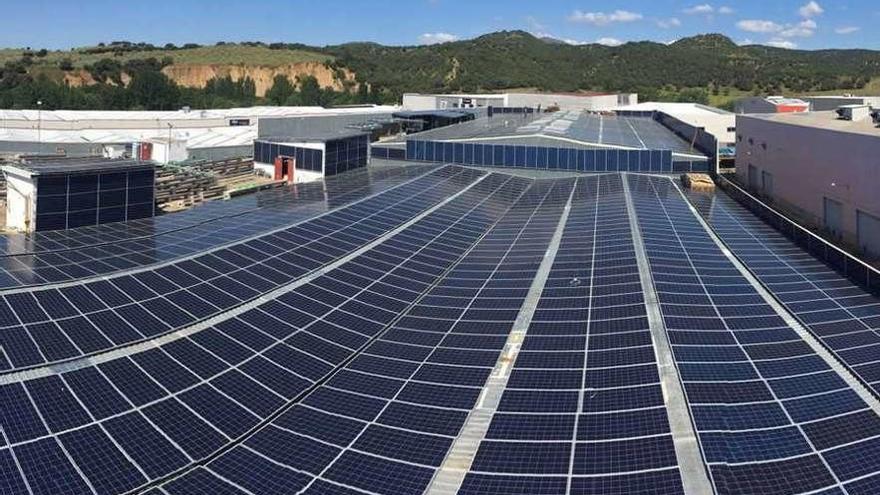 Instalación de paneles solares sobre el techo de una nave industrial.