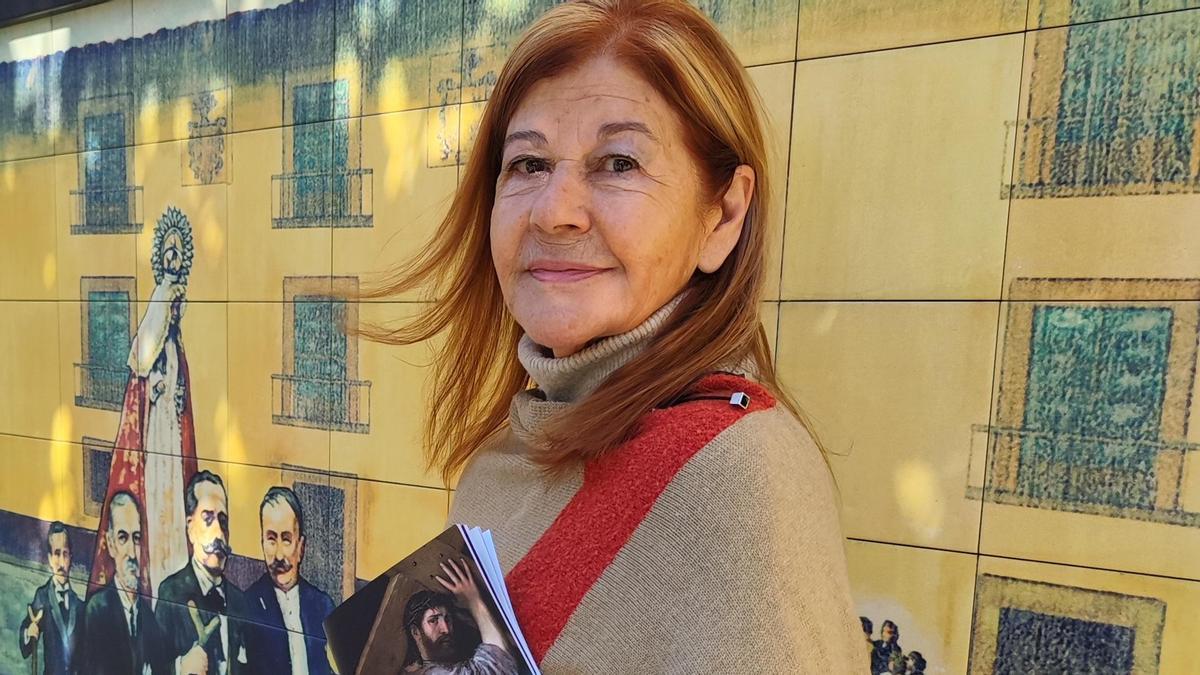 María Teresa Álvarez, con la revista, junto al mural de la Semana Santa de Alfredo Menéndez.