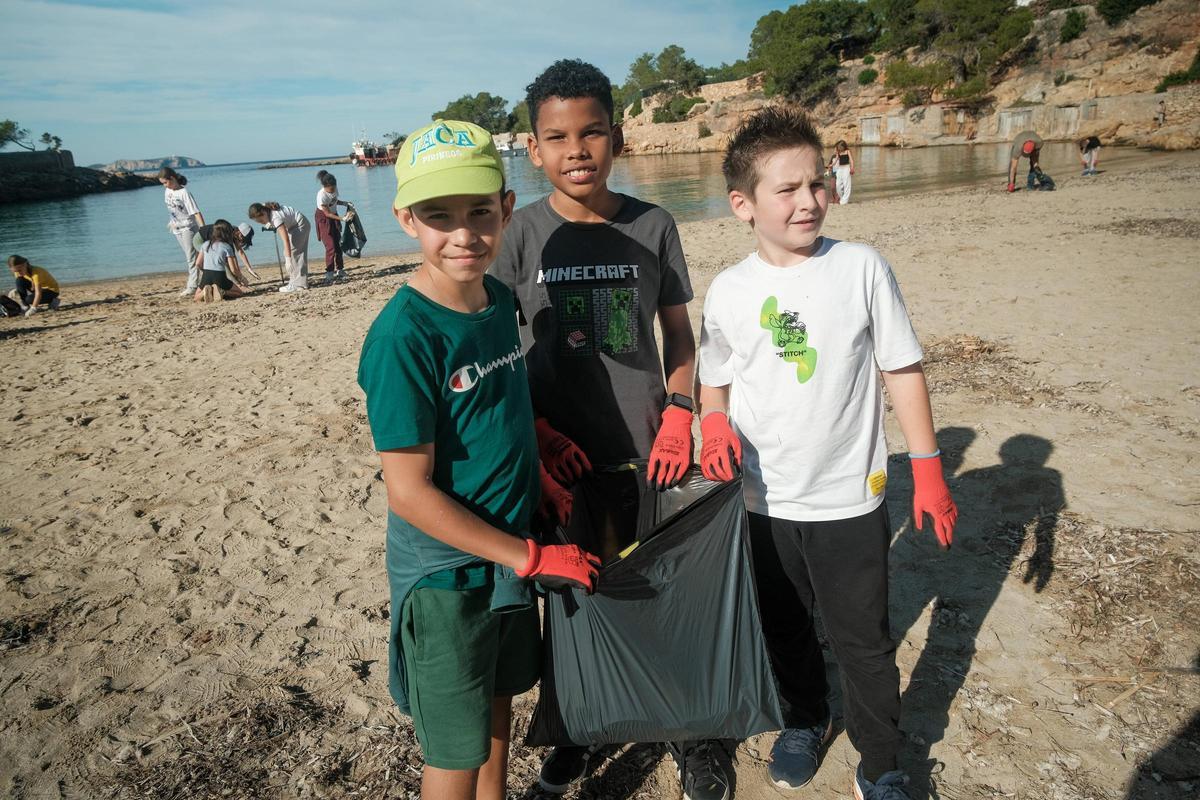 Mario, 'Vini' y Hugo muestran lo que han acumulado en el interior de la bolsa de basura.