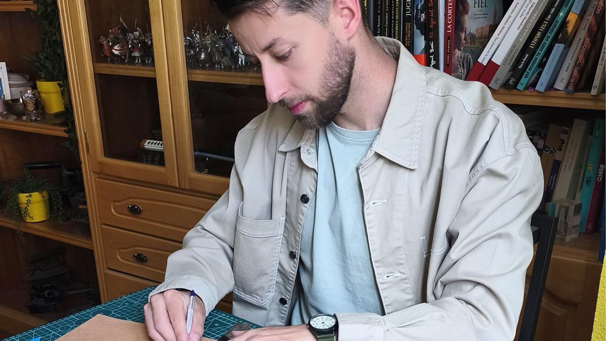 Eduardo López elaborando unos llaveros de cuero.