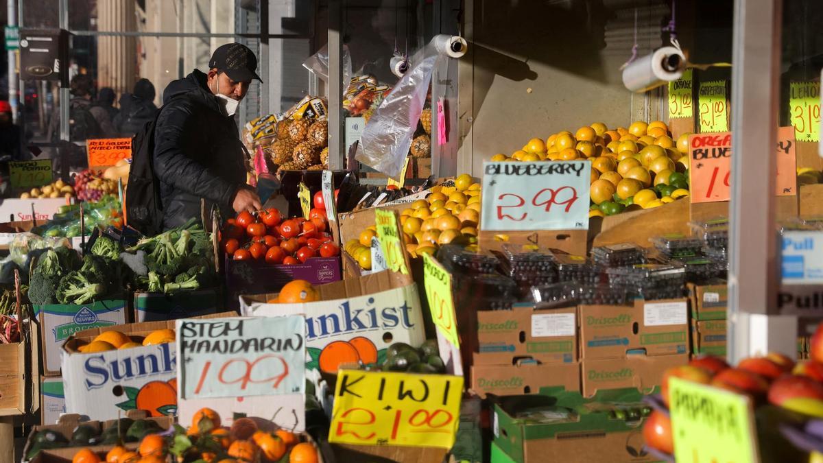 Un joven hace la compra en un puesto de fruta y verdura de Brooklyn.