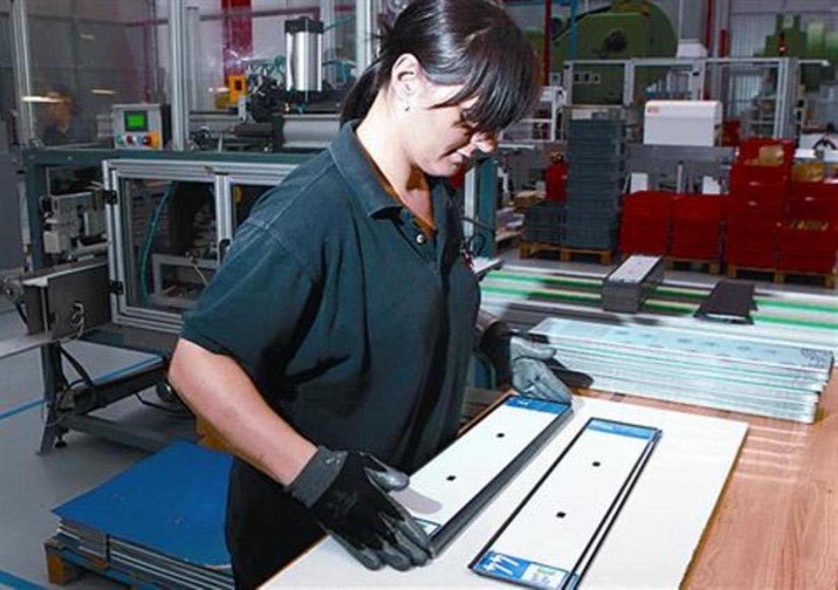 Producció 8 Una empleada amb una de les plaques a la fàbrica. Producció 8 Una empleada amb una de les plaques a la fàbrica.