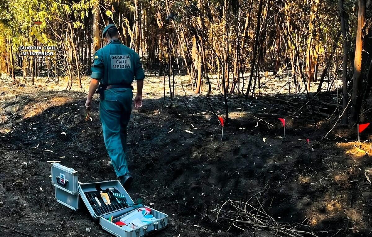 Un agente inspeccionada una de las zonas ordenses calcinadas por el presunto incendiario