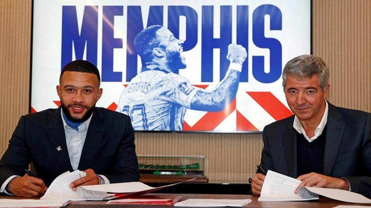 Memphis firma su contrato por dos años y medio con el Atlético junto a Miguel Ángel Marín, consejero delegado del club rojiblanco.