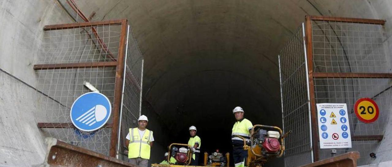 Varios operarios, durante las labores de instalación de las vías en el túnel.