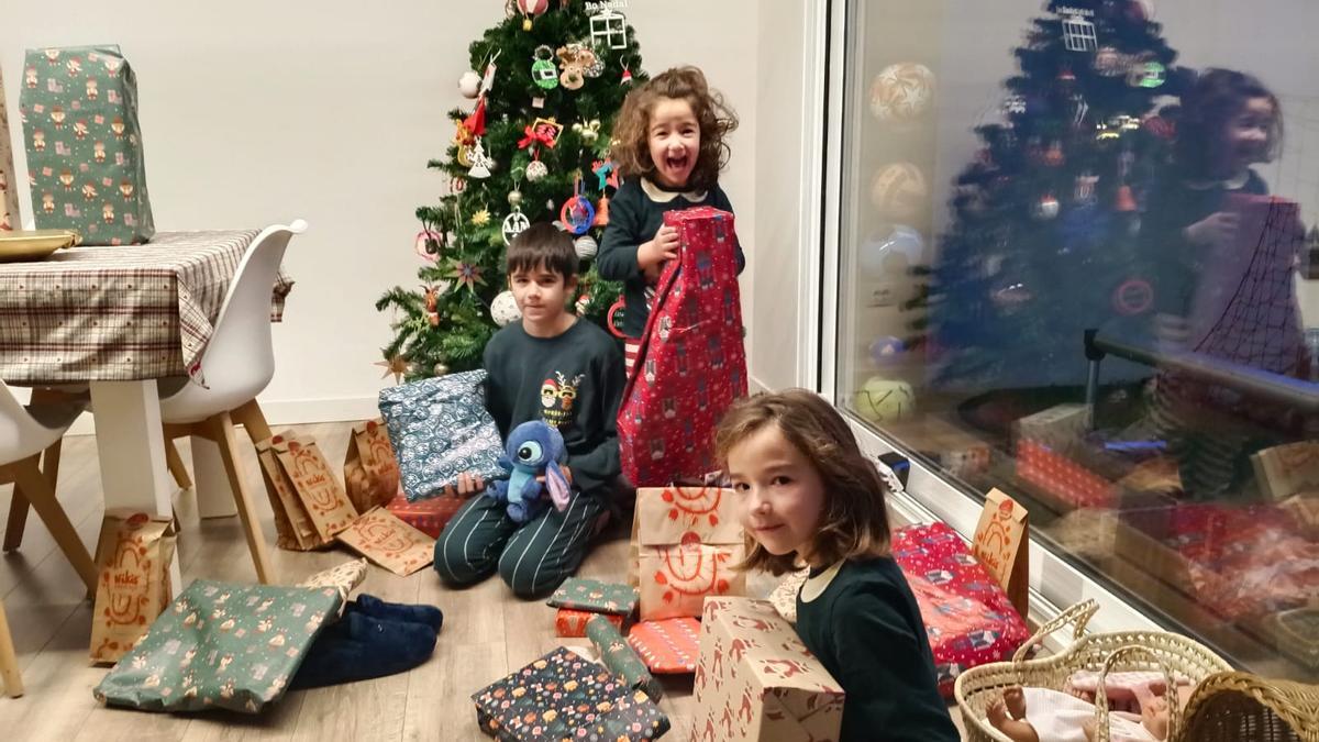Los compostelanos Xiana, Uxía y Xan Vilas abren sus regalos en la mañana de Reyes