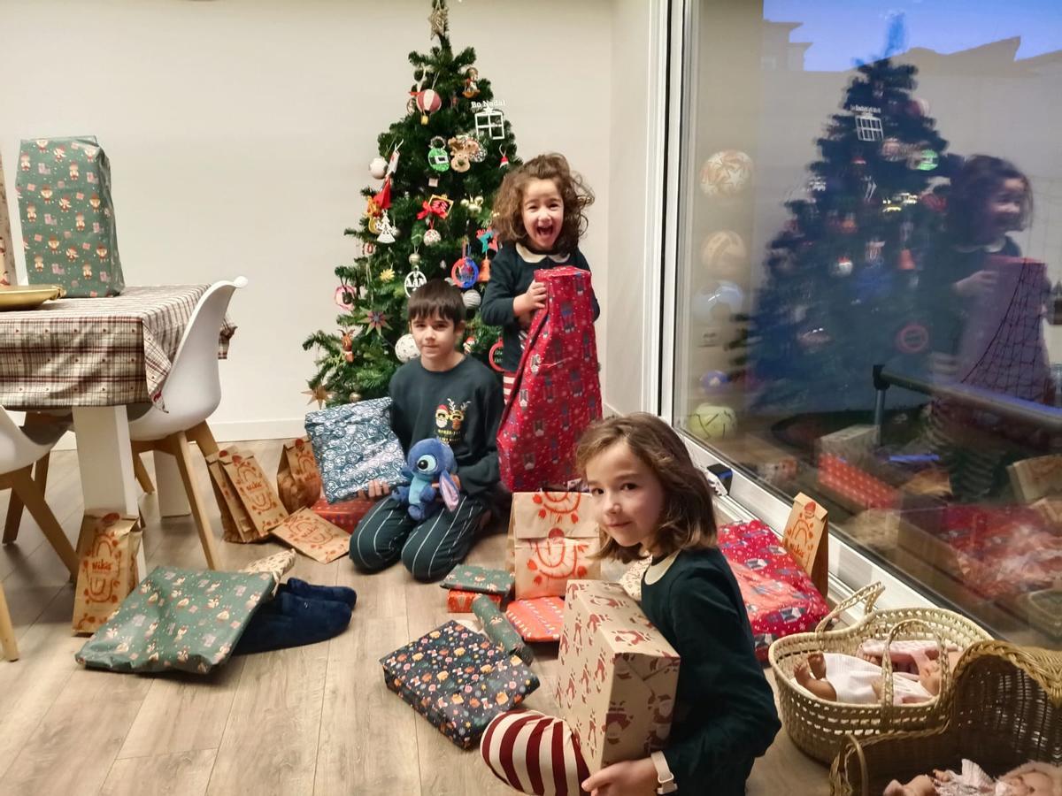 Los compostelanos Xiana, Uxía y Xan Vilas abren sus regalos en la mañana de Reyes
