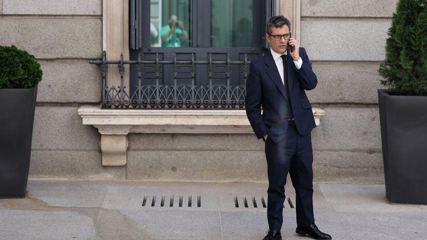 El ministro Félix Bolaños habla por teléfono en el patio del Congreso antes de intervenir en defensa de la Ley de Memoria Democrática.