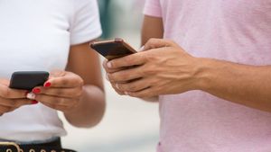 Dos jóvenes usando sus teléfono móviles