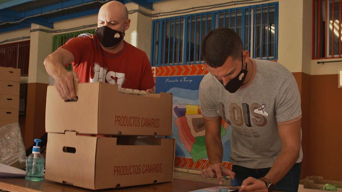 Dos voluntarios de la ‘Operación Cuota Cero’ preparan los alimentos para repartir en los centros. | | E.D.