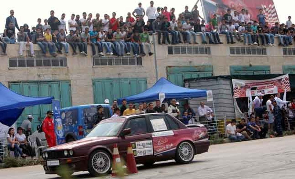 Centenars de palestins miren la carrera de cotxes celebrada a la ciutat de Jenín, a Cisjordània (Palestina).