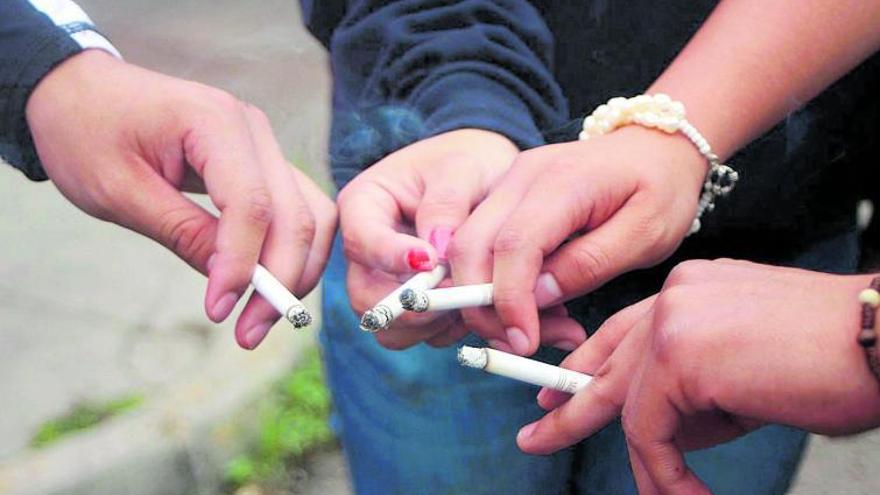 En la imagen se puede observar varios cigarrillos encendidos en un grupo formado por cuatro personas.